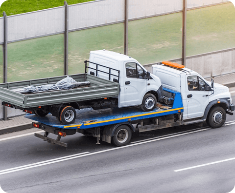 Flatbed tow truck loading a vehicle at the roadside